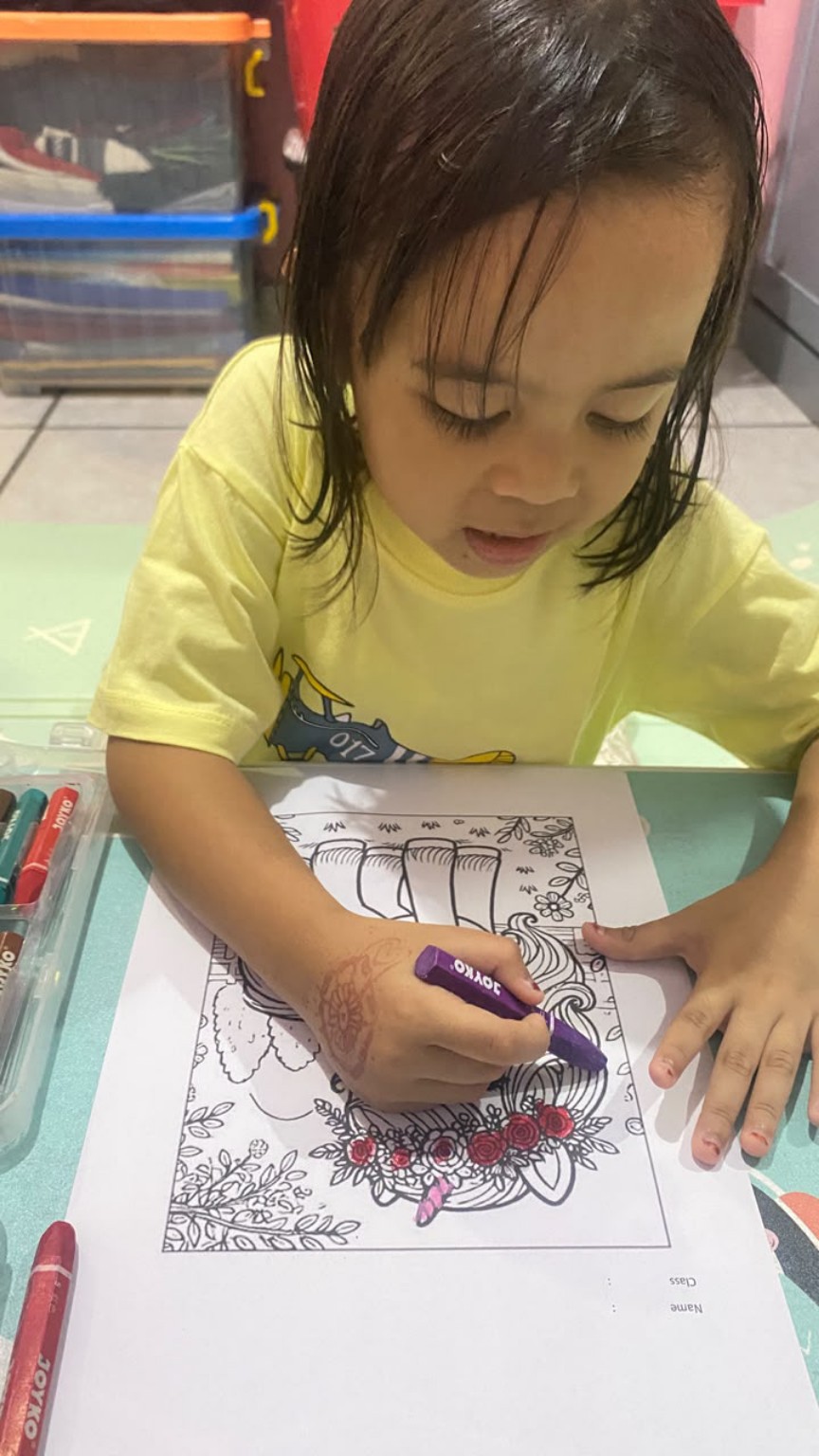 Anak sedang mewarnai dengan fokus